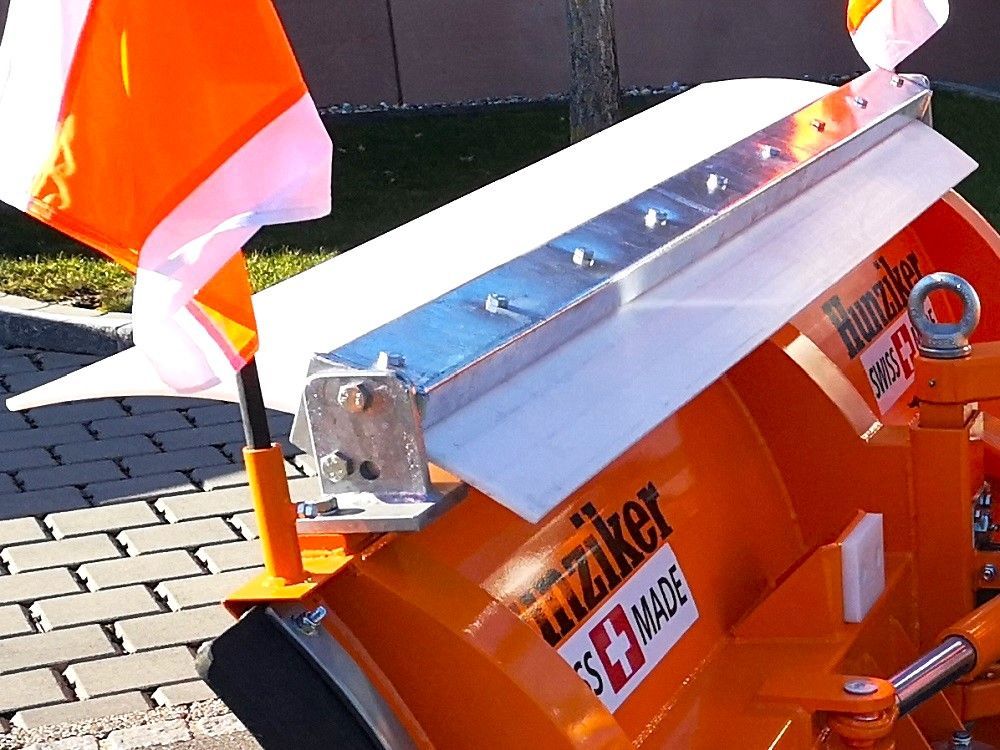 Orangefarbener Schneepflug mit weißer Klinge und Aluminiumblatt, Schweizer Herstellung, mit orangefarbenen Fahnen, im Freien