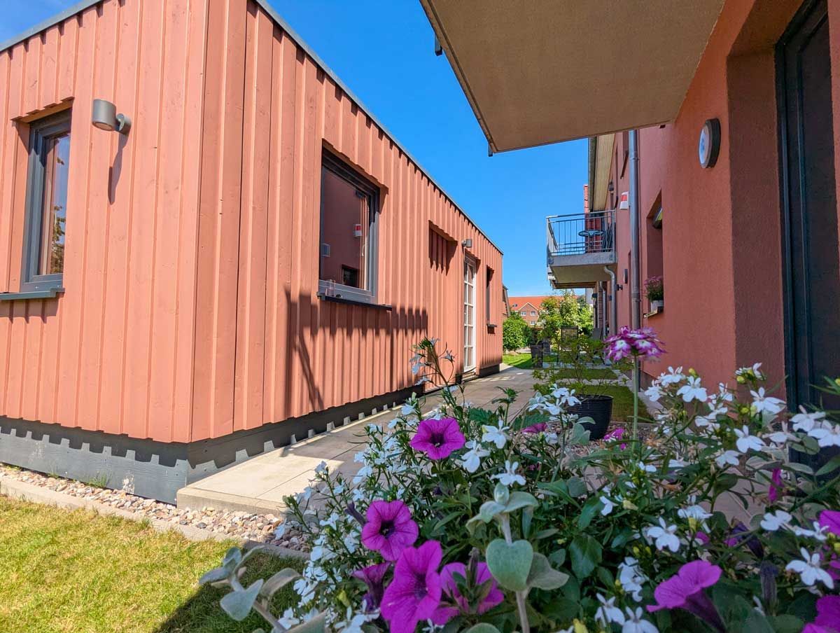 Fahrradschuppen von außen und Gartenbereich der Greenments Ferienwohnungen