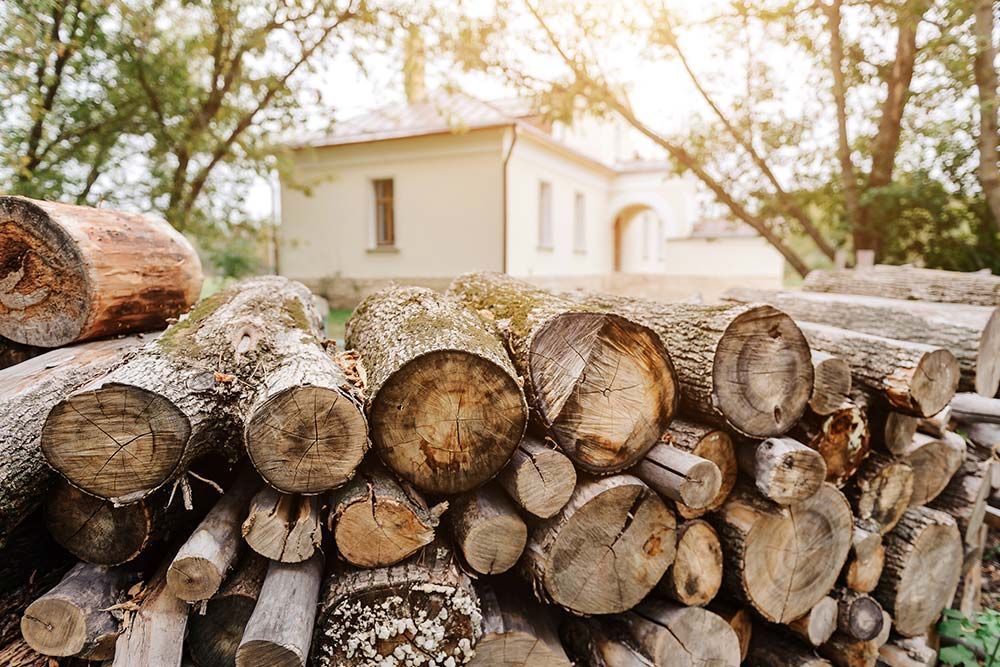 Una pila de troncos se encuentra frente a una casa.