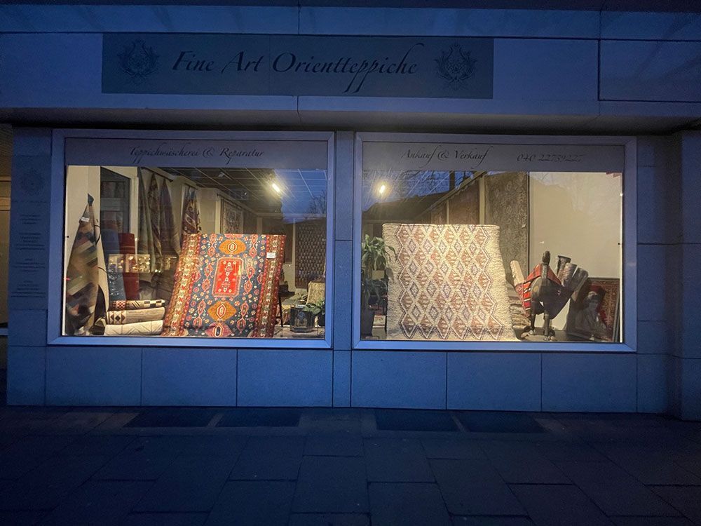 Eine Ladenfront mit einer Teppichauslage im Schaufenster.