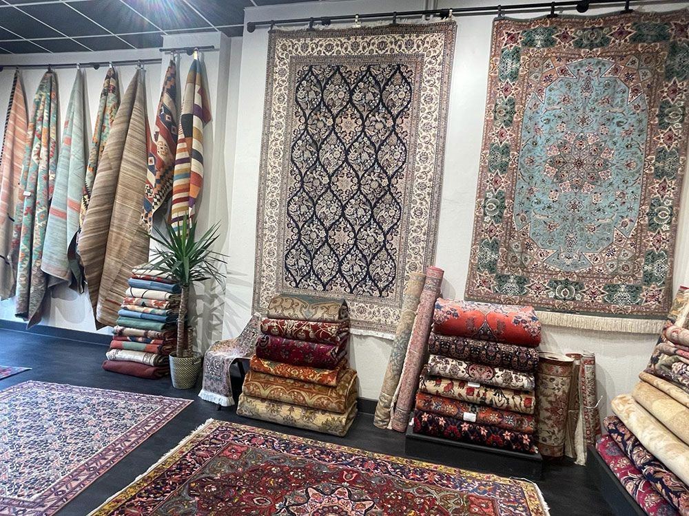 Ein Raum mit vielen Teppichen und einer Pflanze.