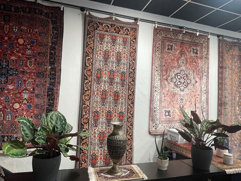 Ein Raum voller Teppiche und Topfpflanzen.