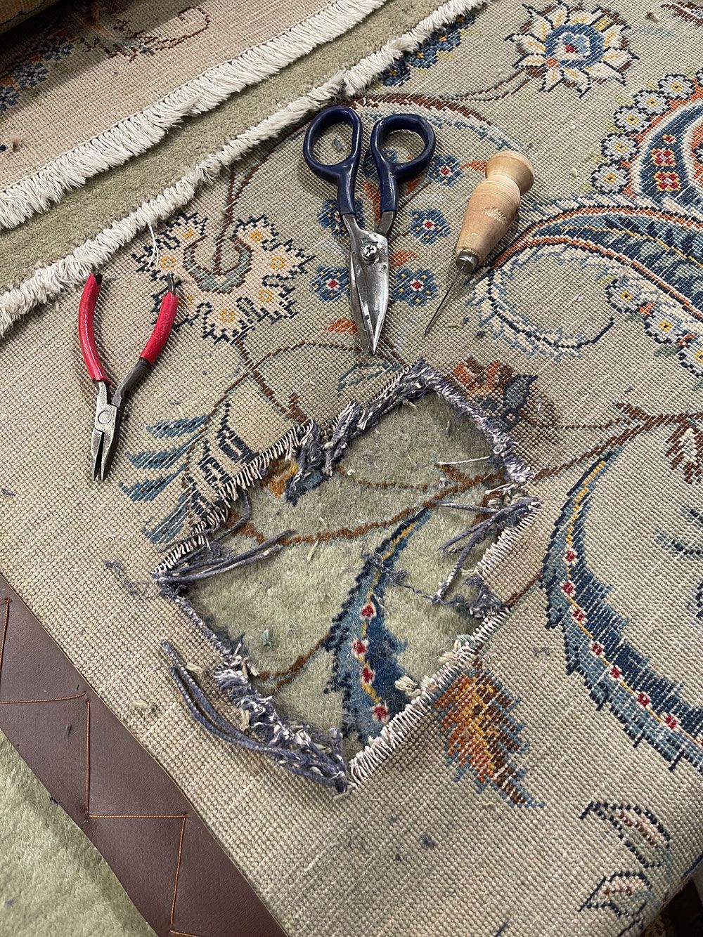 Eine Schere und eine Zange liegen auf einem Teppich.