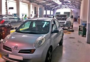 Un coche plateado está aparcado en un garaje.