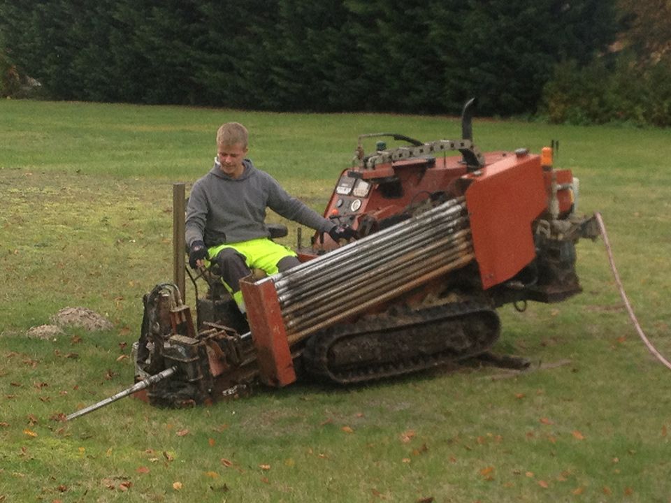 Mann steuert ein Baufahrzeug auf einer Wiese
