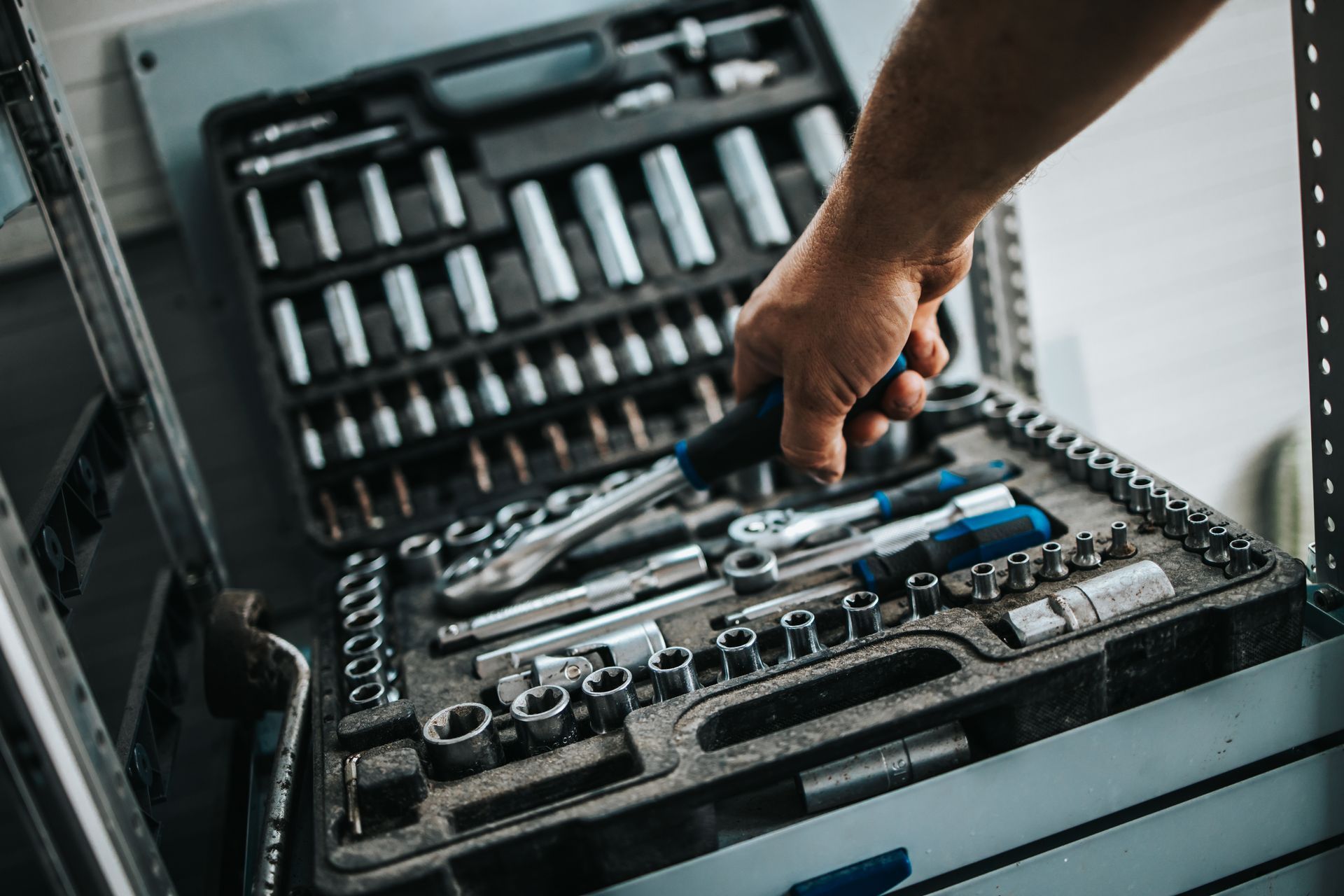 Une main prend un tournevis d'une caisse à outils