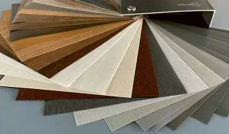 Un abanico de muestras de colores que incluye una variedad de vetas de madera y muestras de laminados de colores sólidos, que abarcan desde marrones cálidos hasta grises fríos.