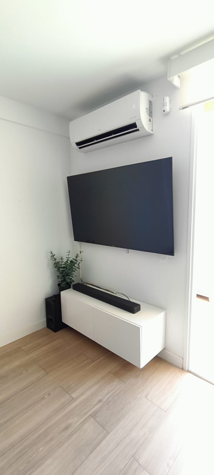 Una sala de estar con un televisor de pantalla plana montado en la pared.