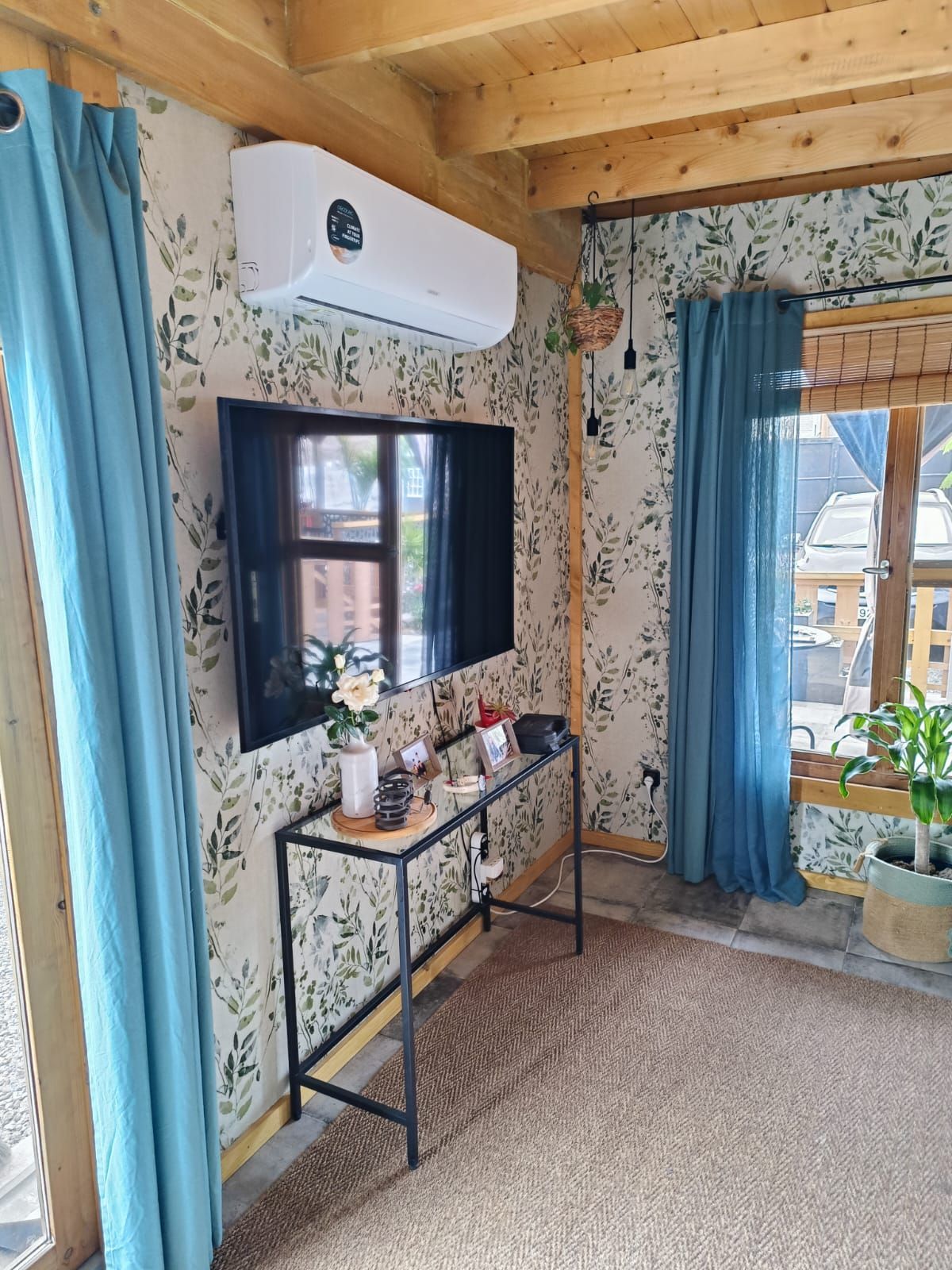 Una sala de estar con una mesa y un televisor en la pared.