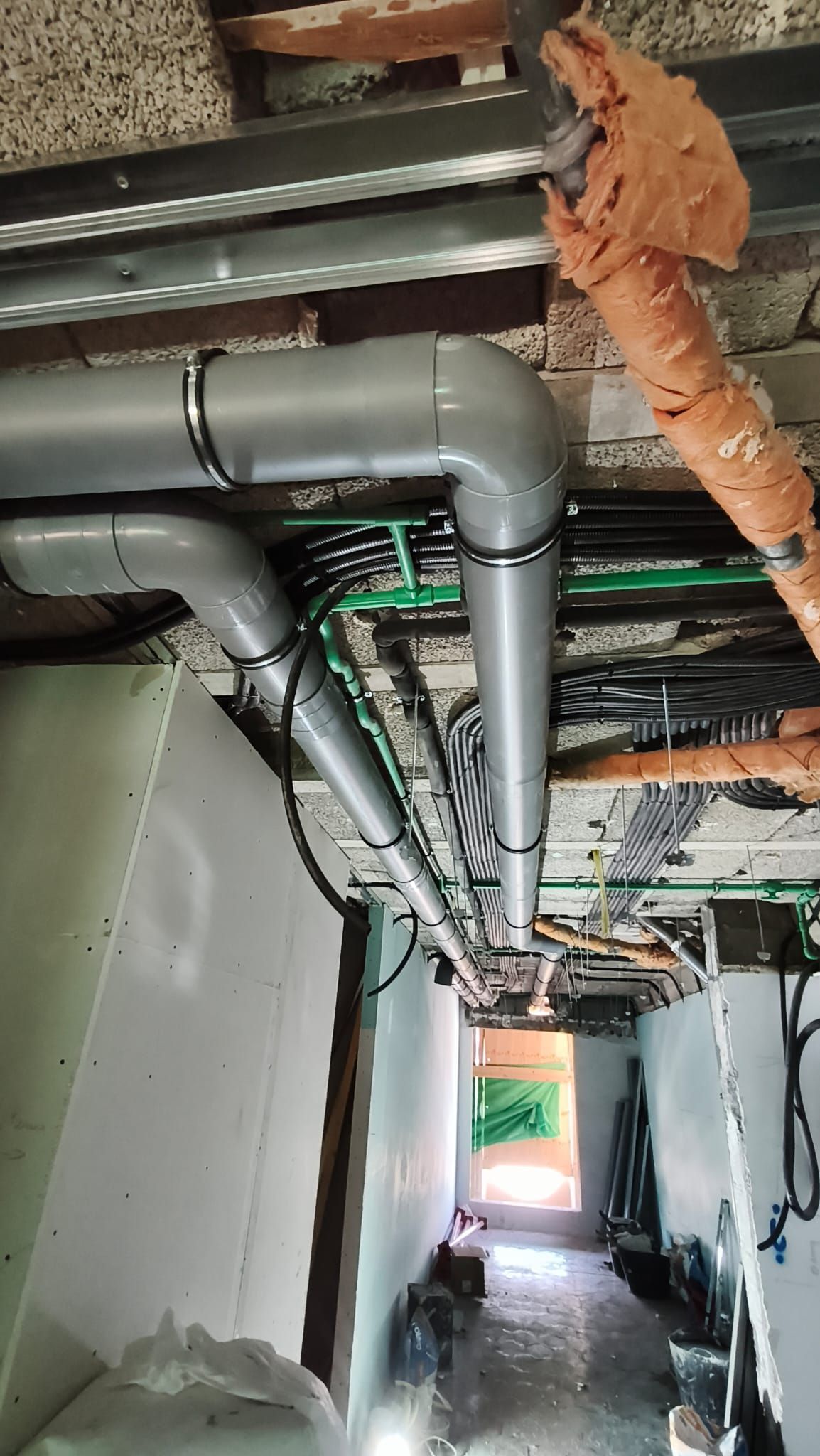 Un montón de tubos cuelgan del techo de un edificio.