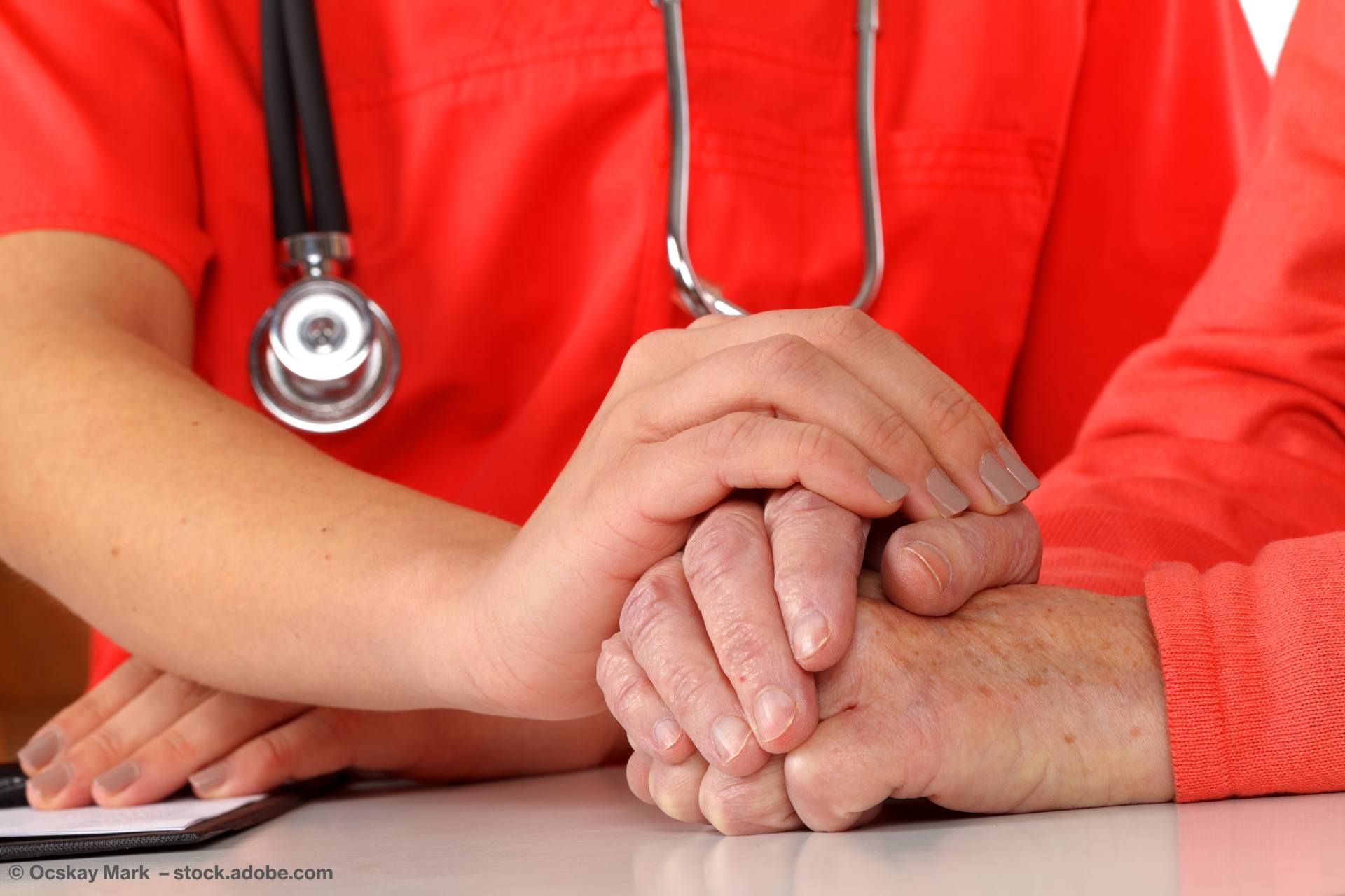 Eine Pflegedienst-Person hält der Hand eines Seniors