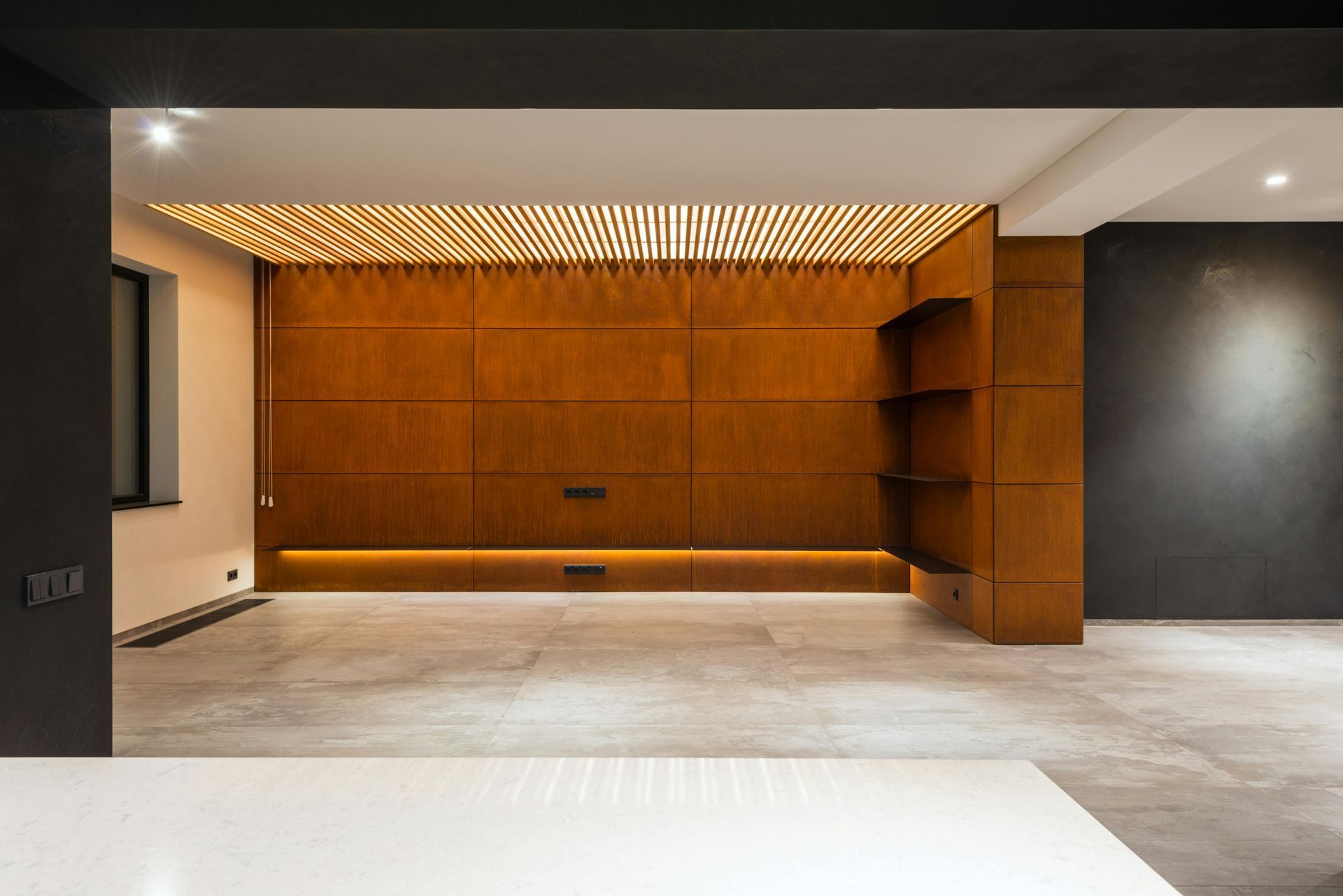Una habitación vacía con una pared de madera y un suelo de hormigón.