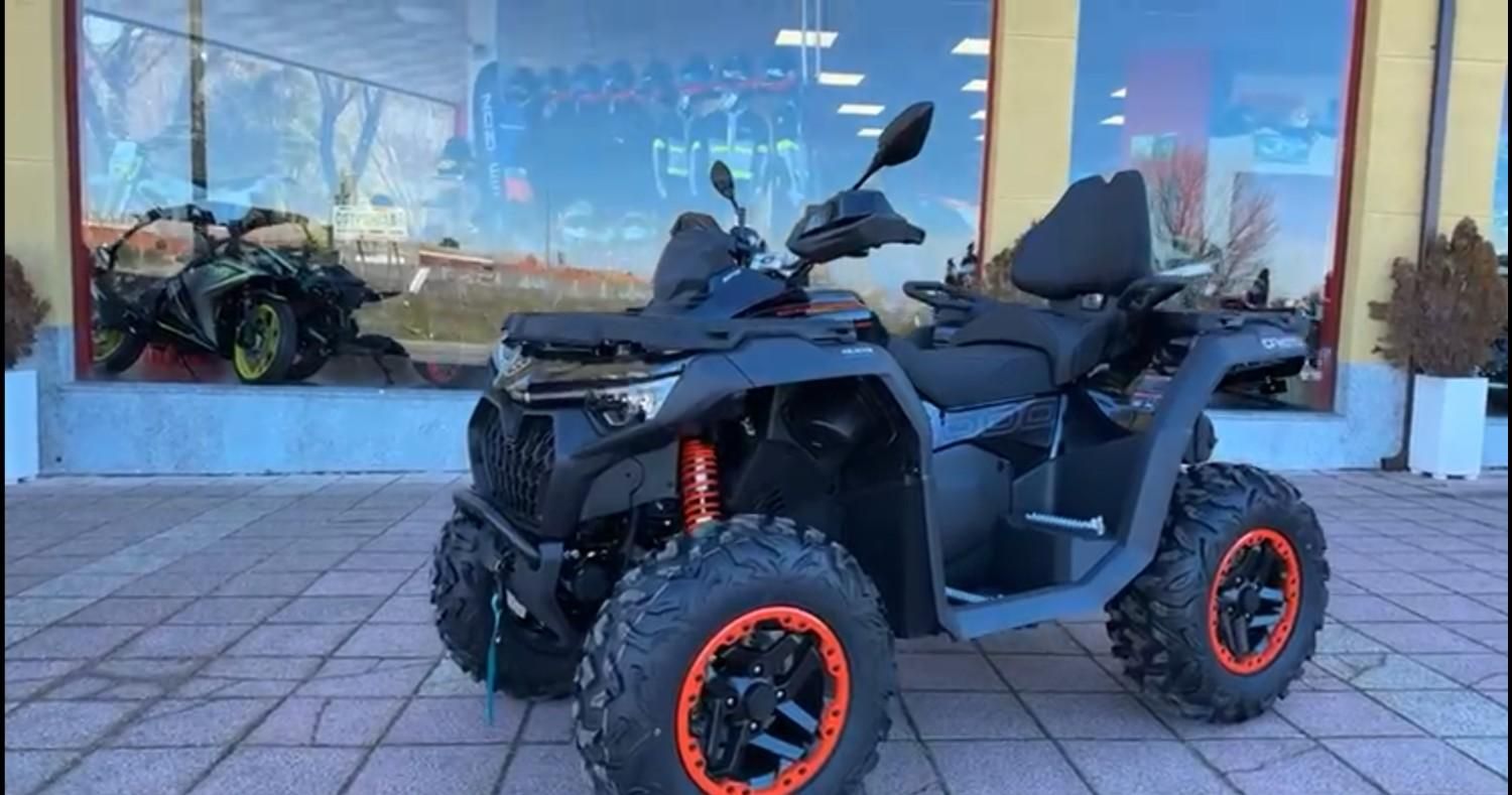 Motocicleta con detalles en rojo y blanco exhibida en una tienda, junto a un tambor rojo.