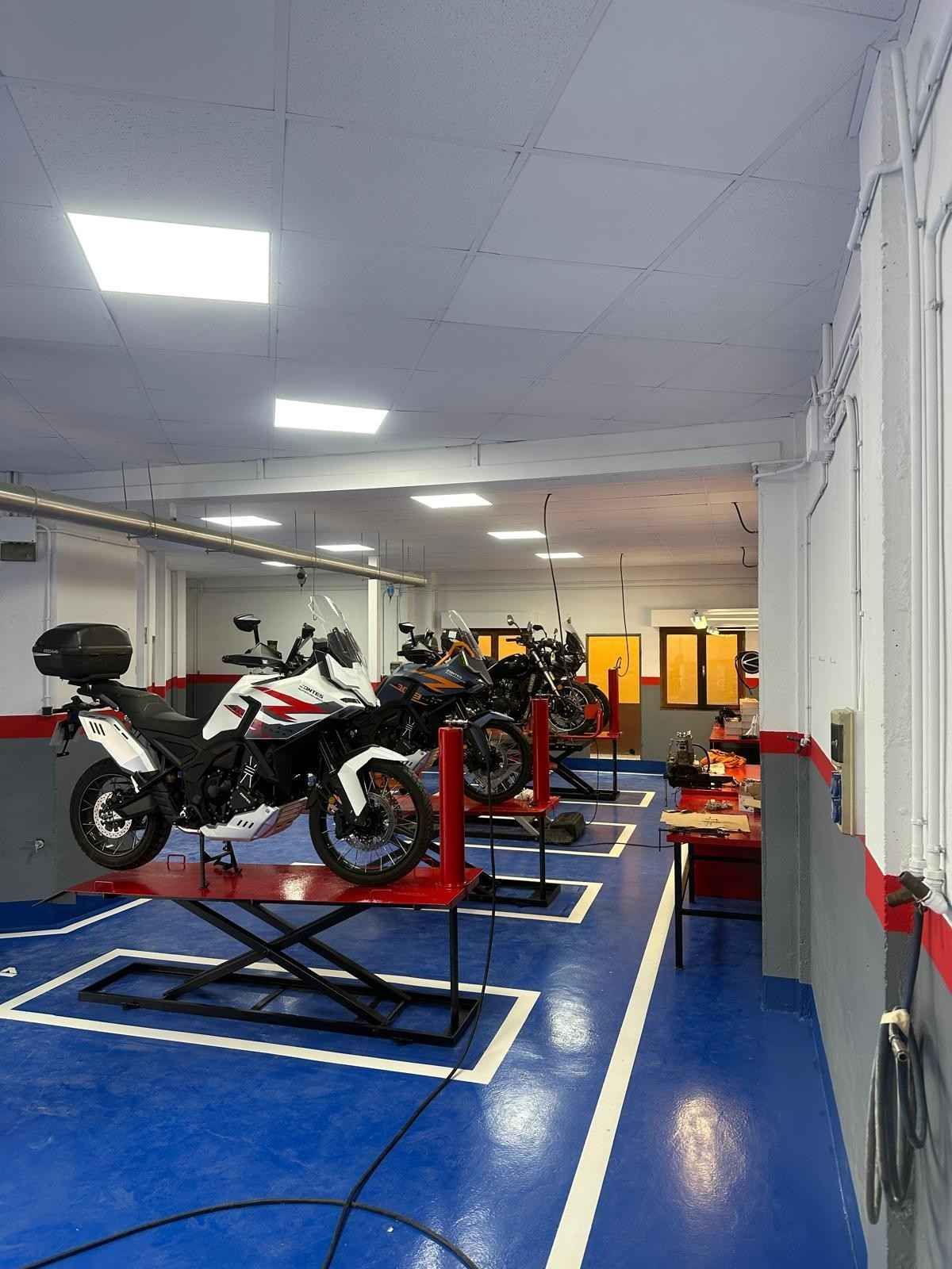 Motocicletas y scooters estacionados en fila afuera de un edificio.