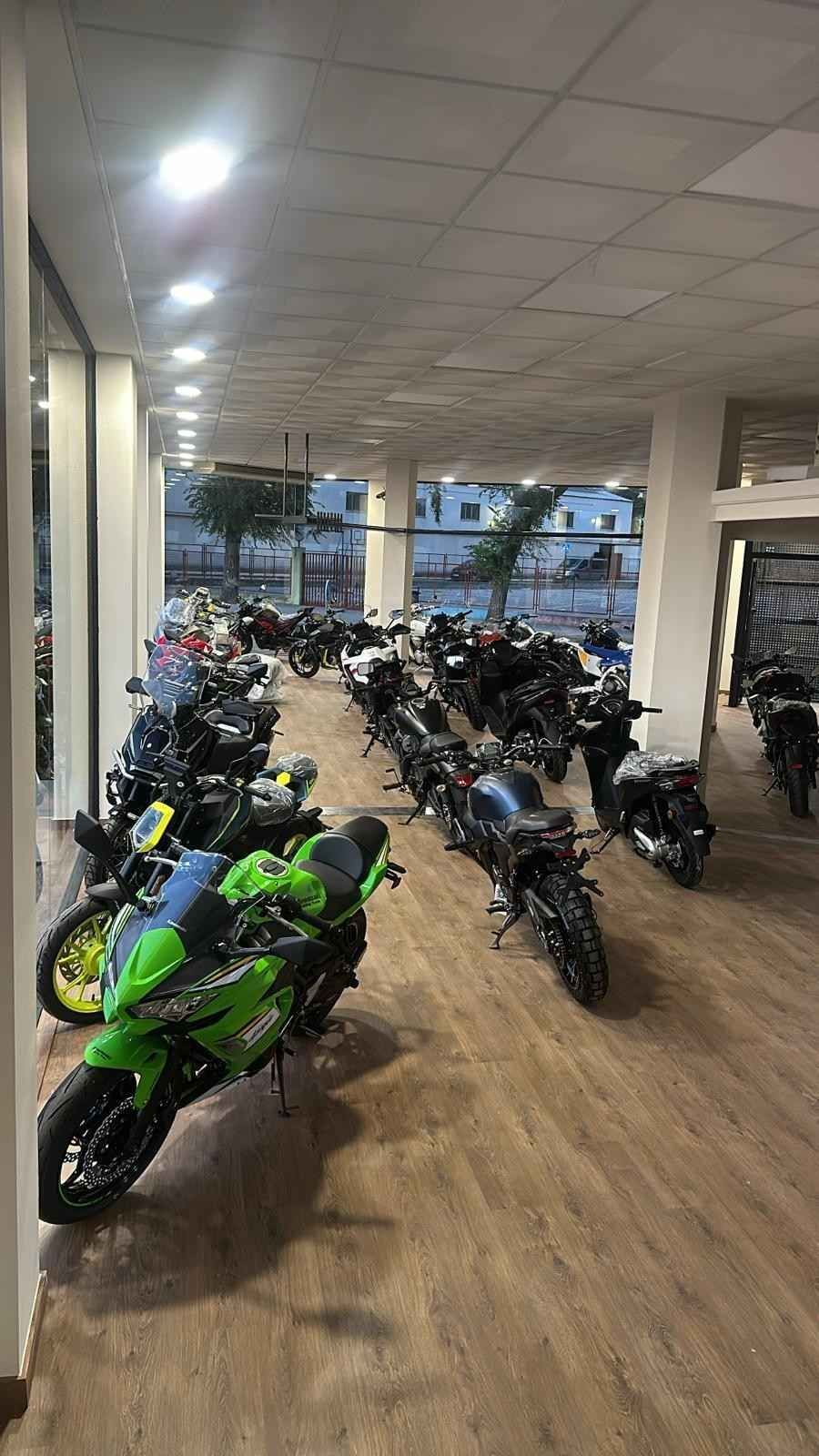 Chaquetas de motocicleta exhibidas en una pared roja en una tienda.