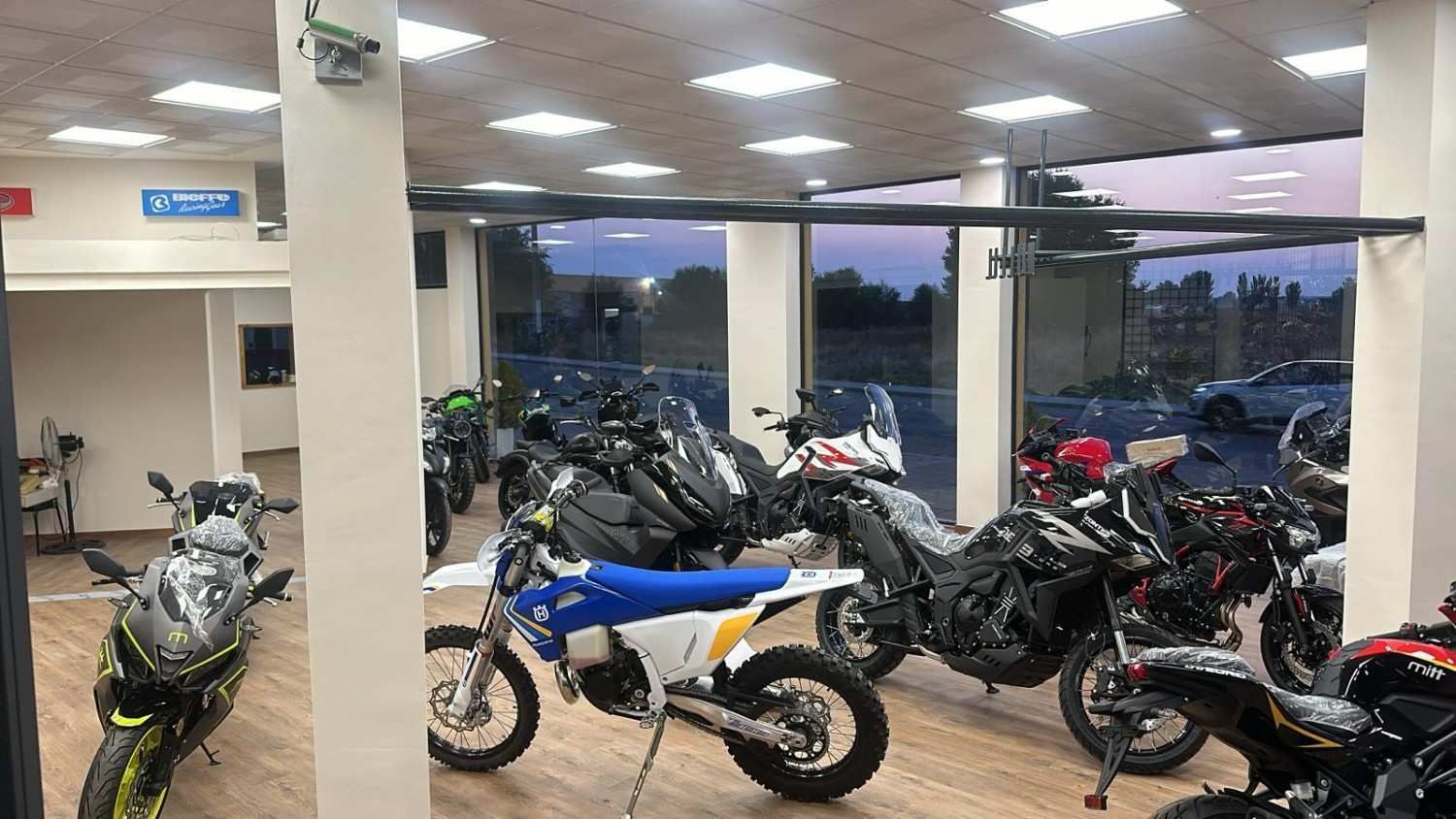 Tres patinetes amarrados a un remolque rojo estacionado en la acera. Uno azul, dos rojos.