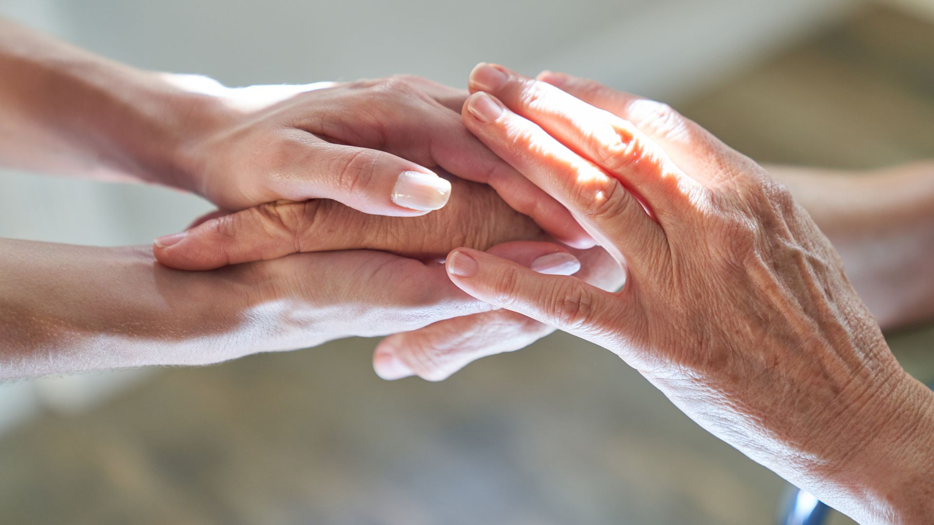 Femme jeune tenant les mains d'une autre femme âgée