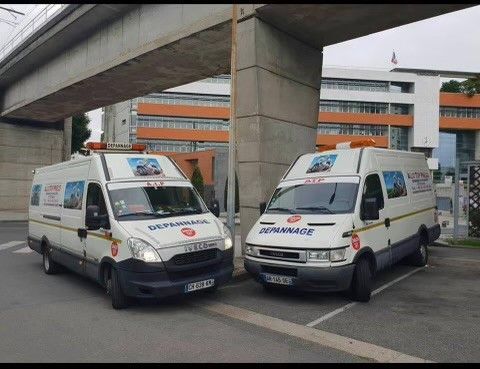 Deux camions de Allô Top Pneus de face sous un viaduc