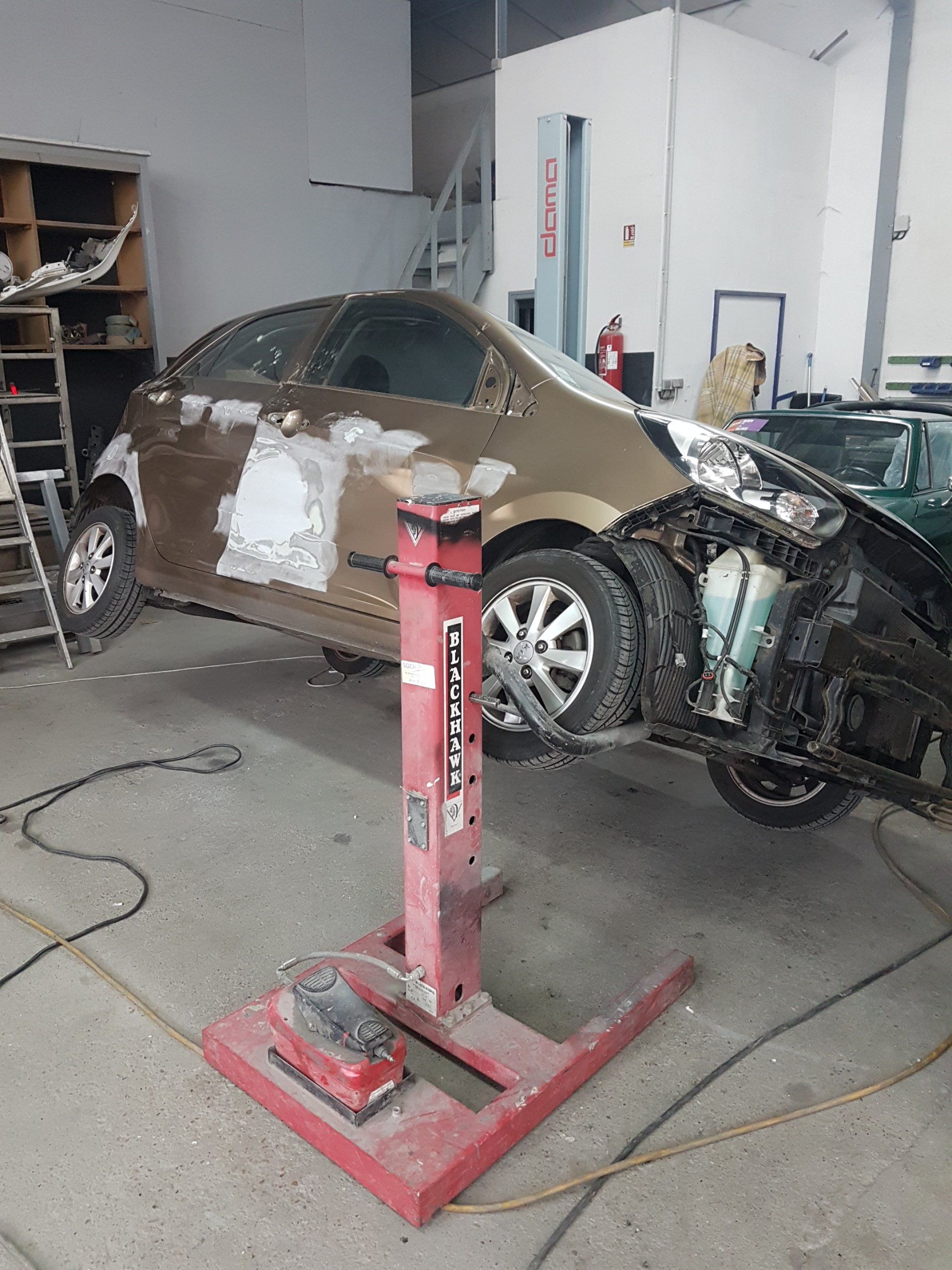 Voiture rouge penchée pour les réparations