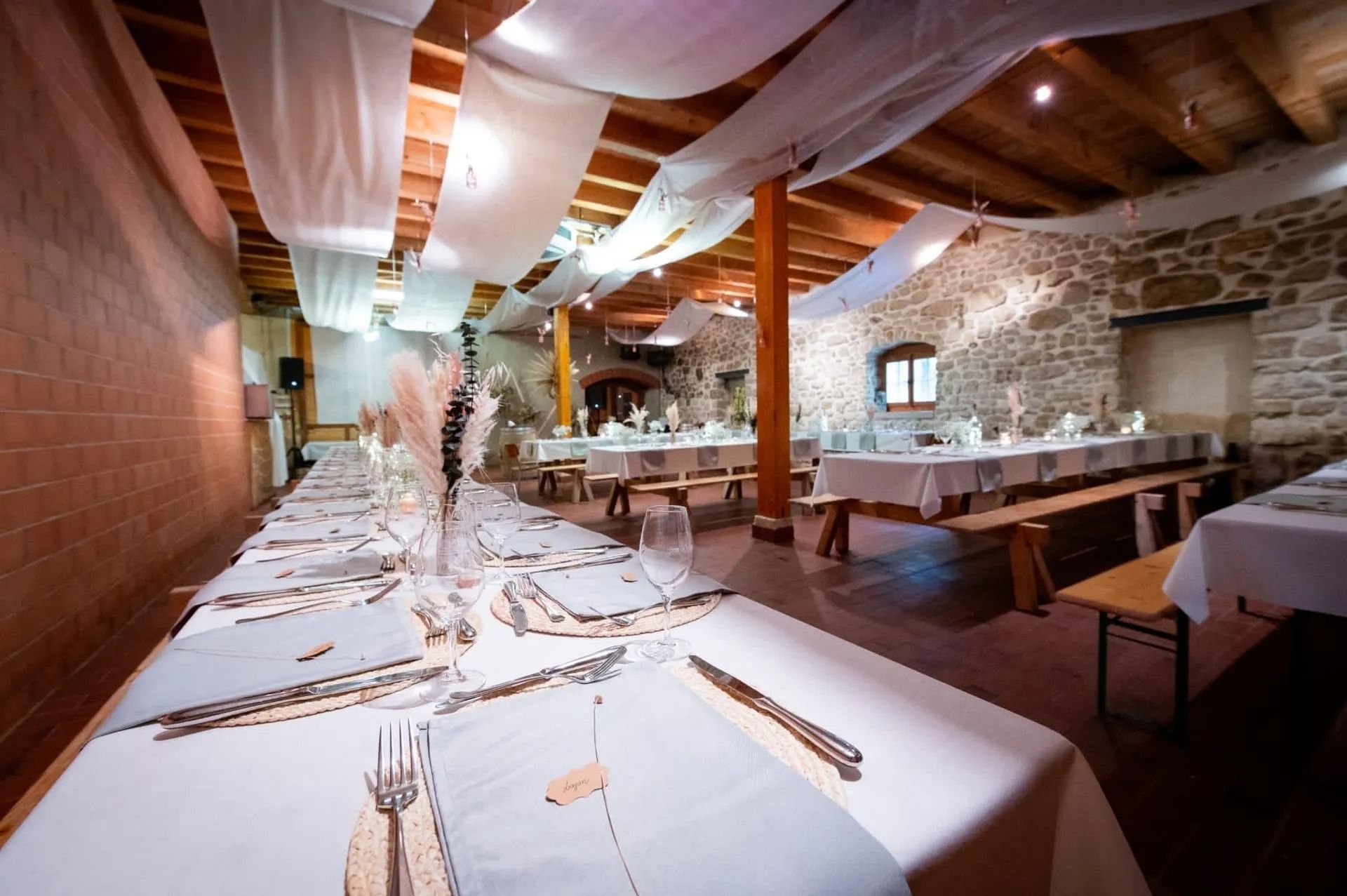 De longues tables sont dressées pour une réception de mariage.