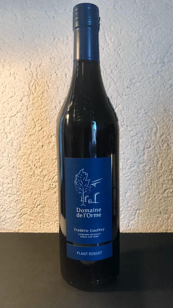 Bouteille de vin rouge avec étiquette bleue et bouchon bleu foncé.