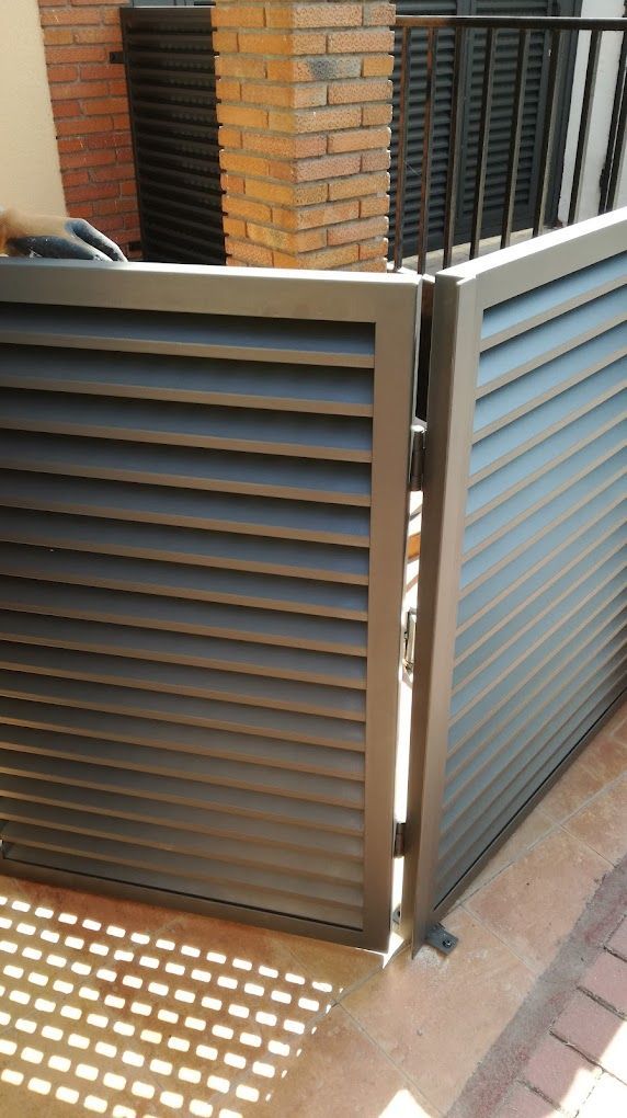 Una valla con una pared de ladrillos al fondo