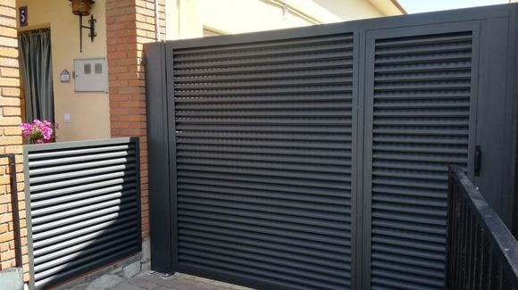 Una puerta negra está frente a un edificio de ladrillos.