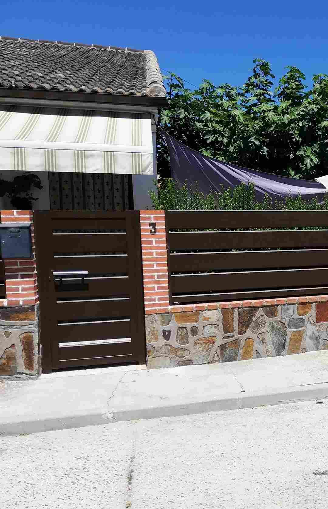 Una casa con una puerta de madera y una pared de ladrillo