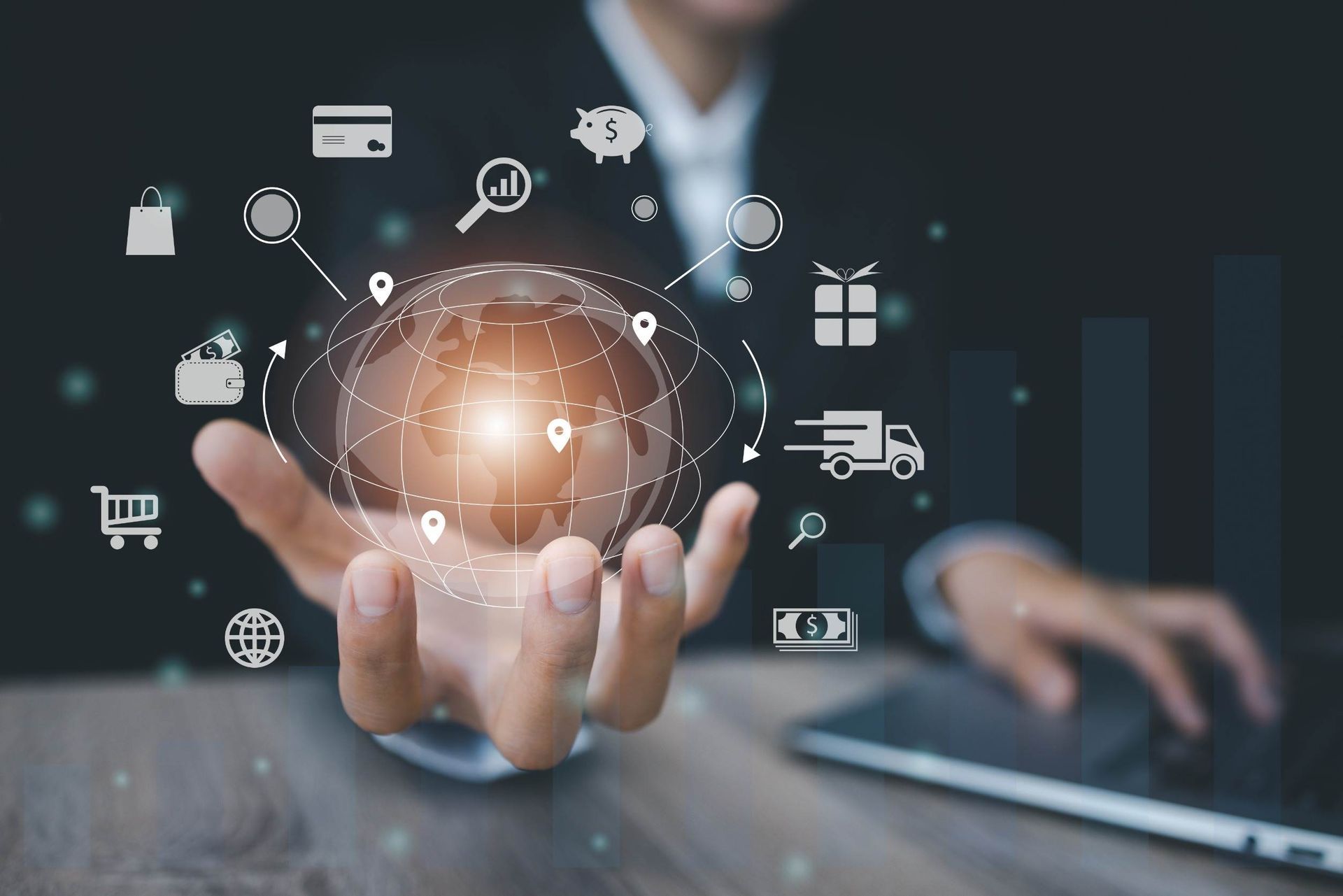 Una persona está escribiendo en una computadora portátil y sostiene un globo terráqueo en su mano.