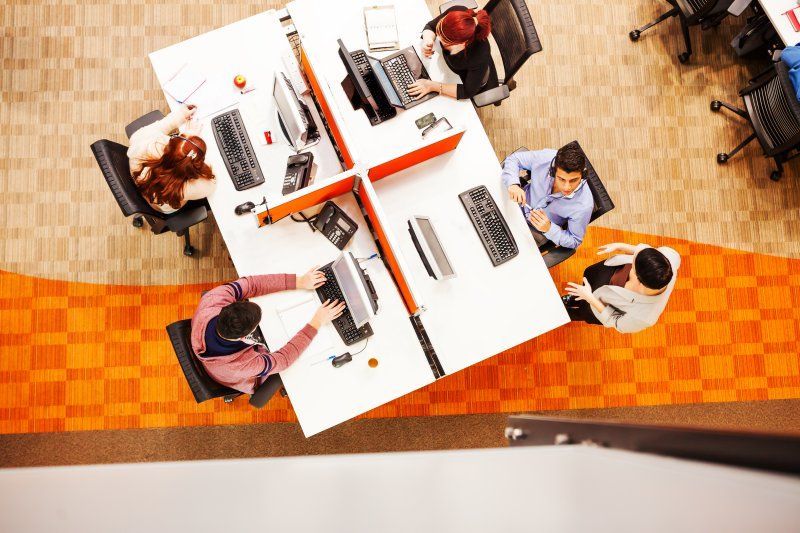 Un grupo de personas está sentada en una mesa en una oficina.
