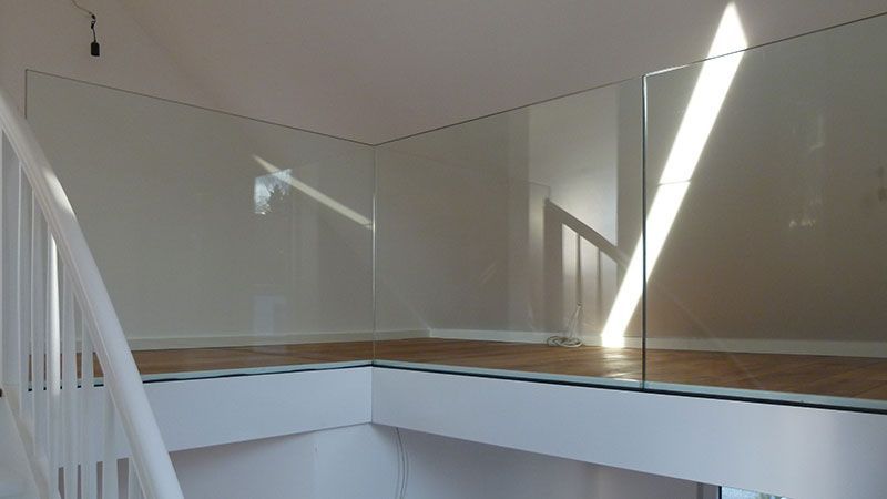 Eine Treppe mit einem Glasgeländer und einem weißen Geländer