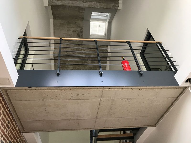 Eine Treppe mit Balkon und einem Feuerlöscher darauf