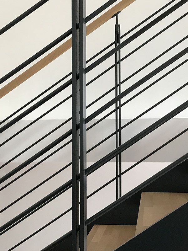 Eine Nahaufnahme einer Treppe mit einem schwarzen Geländer
