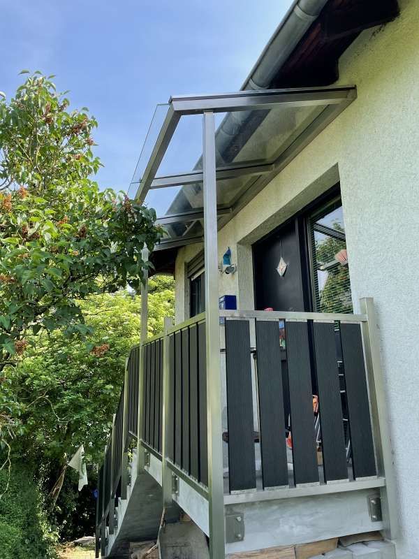 Ein Haus mit einem Balkon und einer Treppe an der Seite