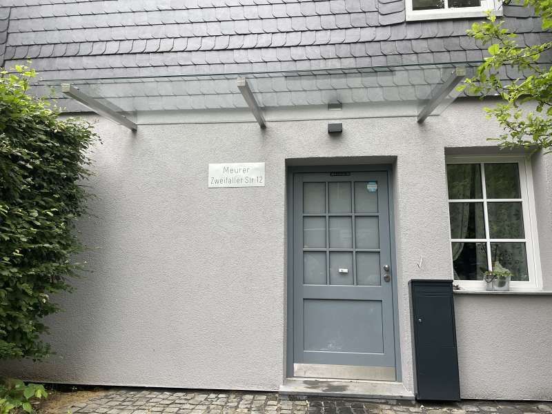 Die Eingangstür eines Hauses mit einem Glasdach darüber