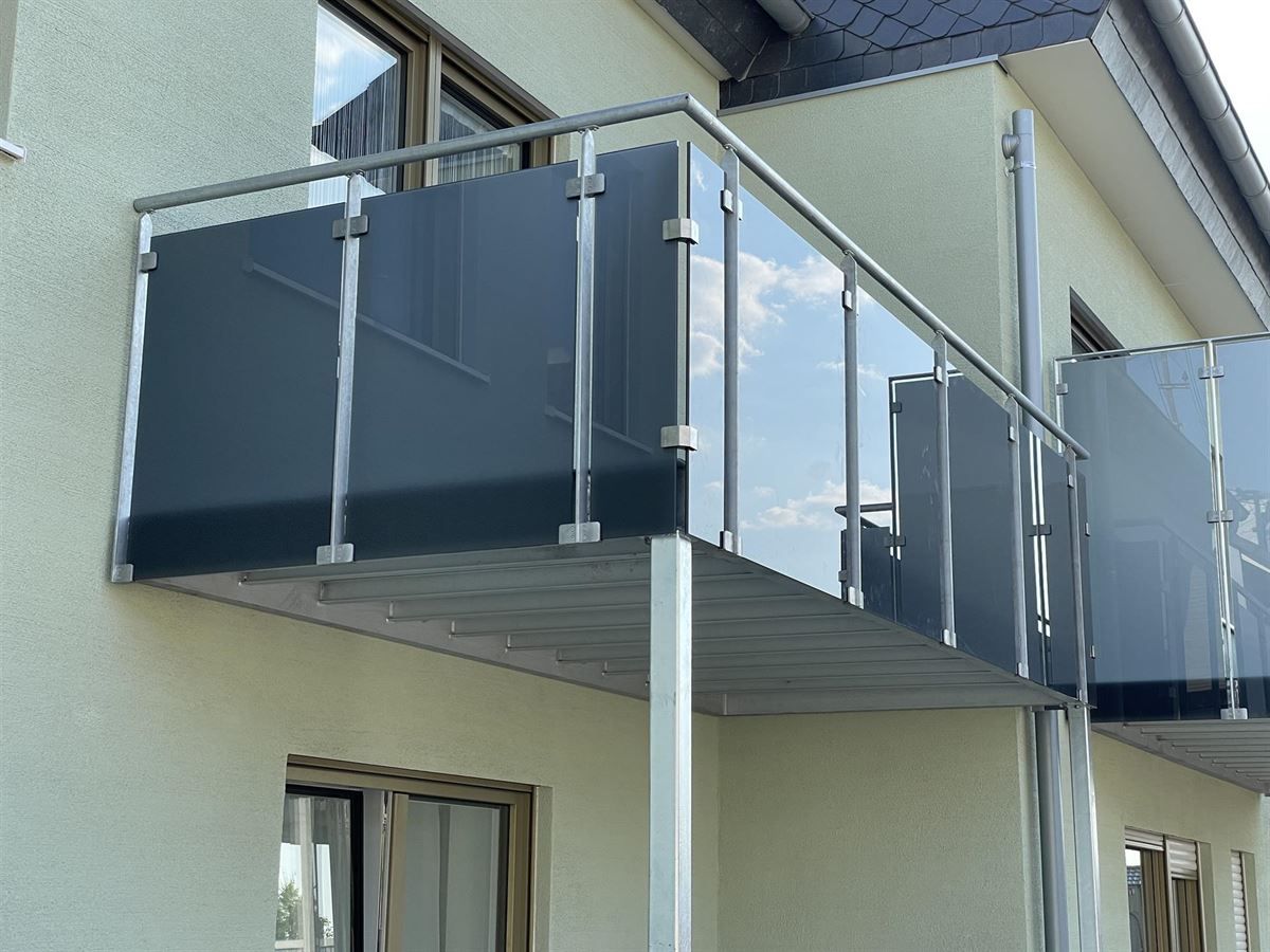 Ein Balkon mit einem Edelstahlgeländer an der Seite eines Gebäudes