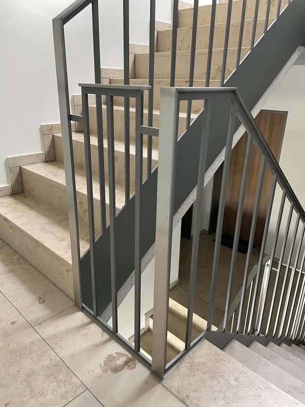 Eine Nahaufnahme einer Treppe mit einem Metallgeländer.
