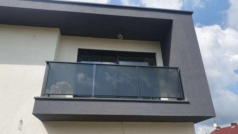 Ein Balkon an der Seite eines Gebäudes mit einem schwarzen Geländer.