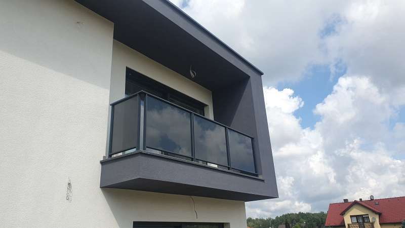 Ein modernes Haus mit einem Balkon an der Seite.