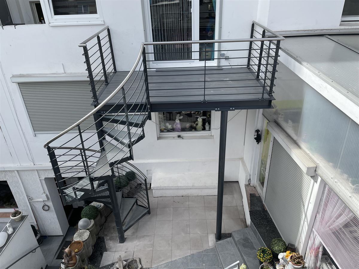 Eine Luftaufnahme eines Hauses mit einer Wendeltreppe und einem Balkon.