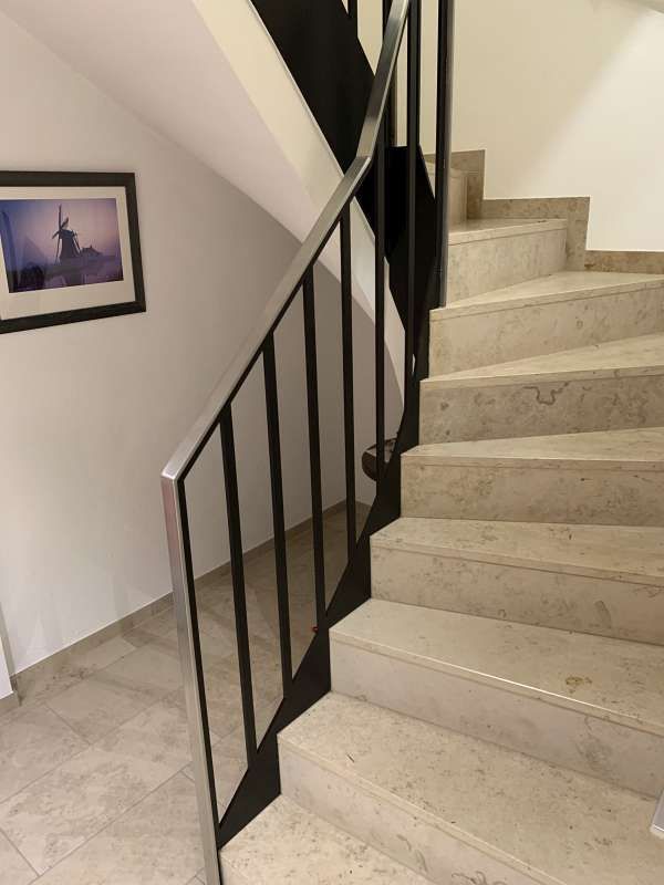 Eine Treppe mit schwarzem Geländer und einem Bild an der Wand