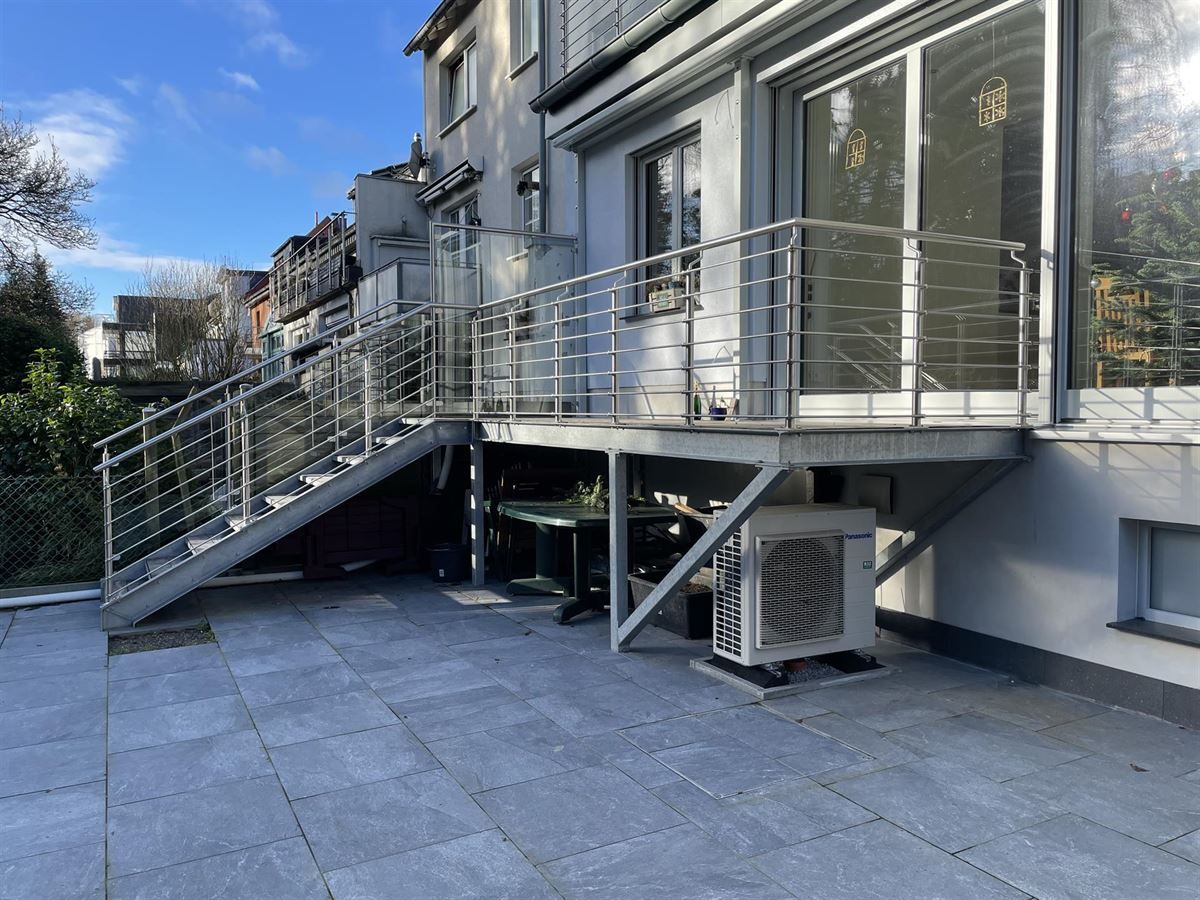 Ein Balkon mit Treppe und Edelstahlgeländer an der Seite eines Gebäudes.