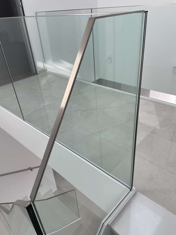 Eine Nahaufnahme von einem Glasgeländer auf einer Treppe