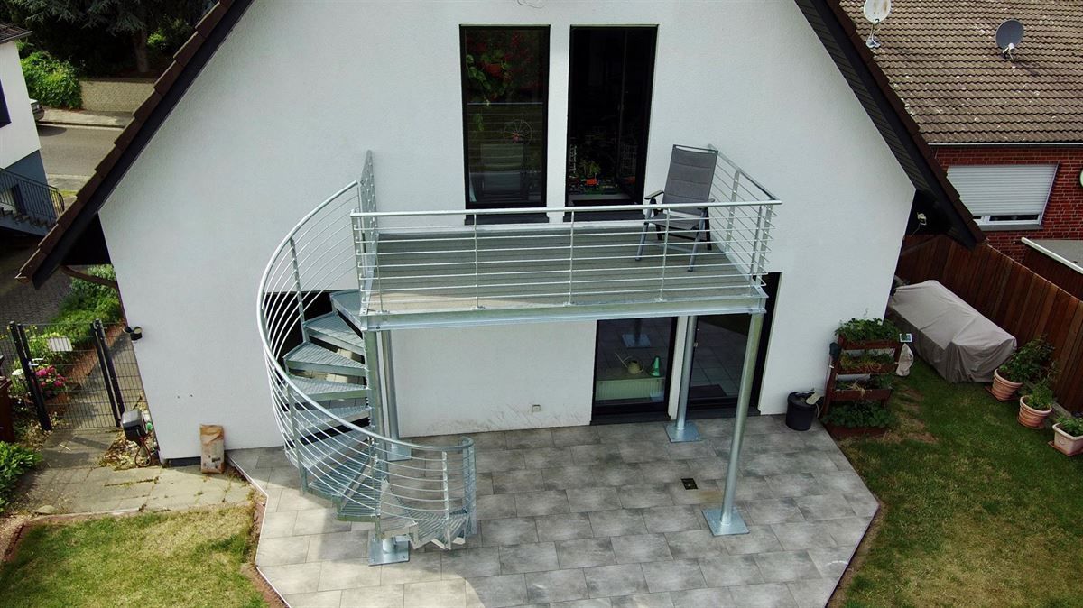 Eine Luftaufnahme eines Hauses mit einer Wendeltreppe und einem Balkon.