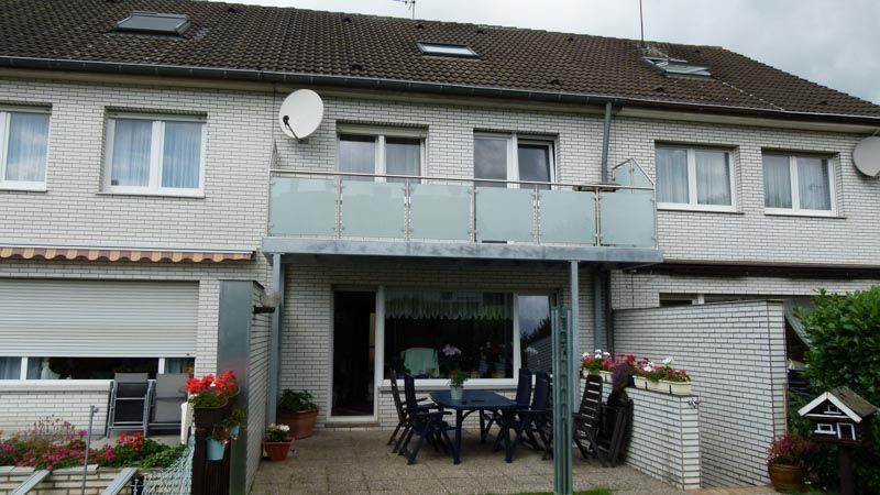 Ein Haus mit einem Balkon und einem Tisch und Stühlen darauf