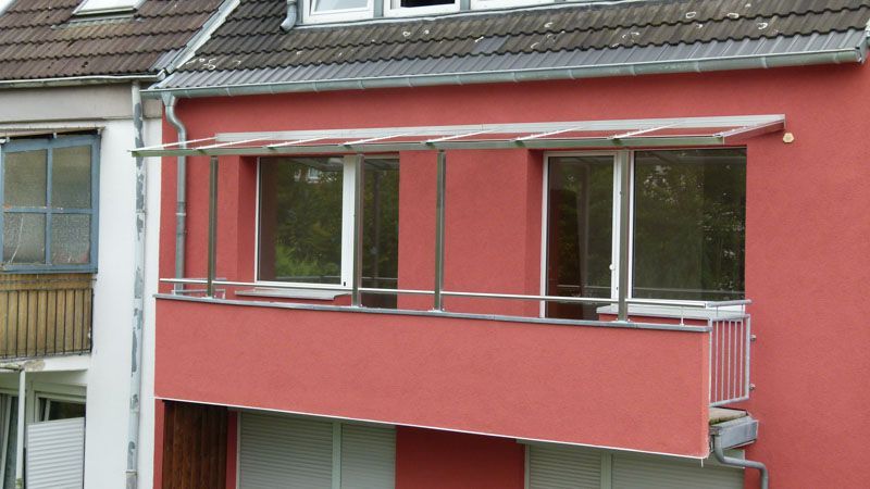 Ein rotes Gebäude mit einem Balkon an der Seite