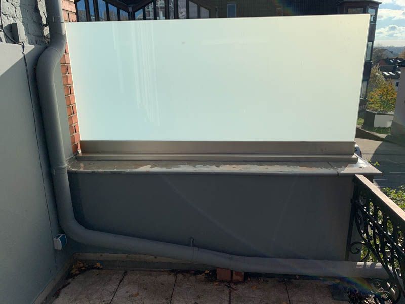 Ein Balkon mit einer weißen Wand und einem Abflussrohr