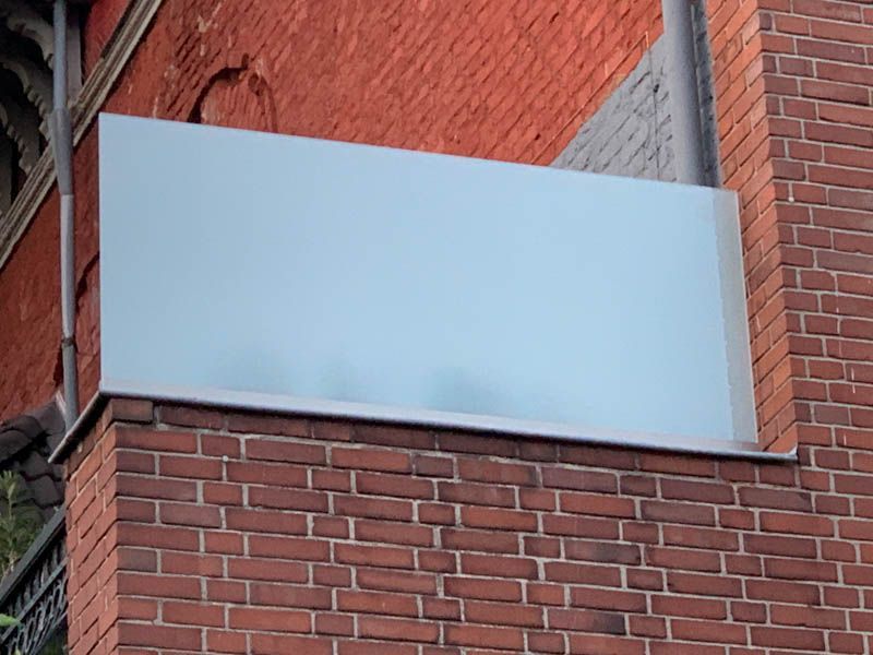 Eine Backsteinmauer mit einem weißen Schild darauf