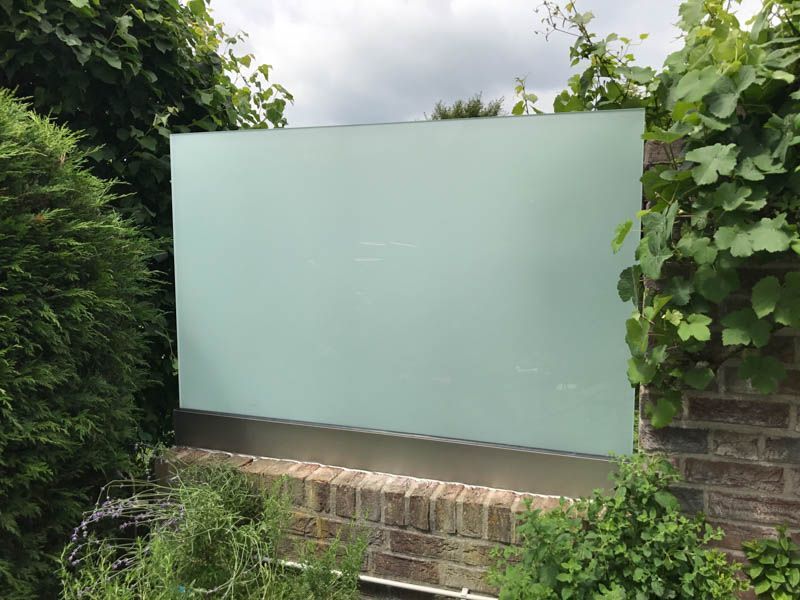 Auf einer Backsteinmauer steht eine große weiße Tafel.