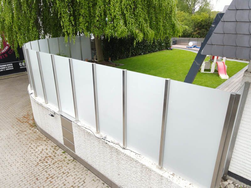 Ein weißer Zaun mit einer Rutsche im Hintergrund